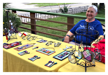 Barbara Wakefield, a Gainesville Fine Arts Association artist, sits behind her stained glass art.