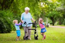 Old woman walking outside with grandchildren